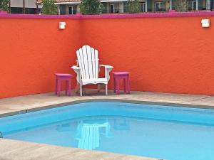 a pool with a blue chair and a blue chair chair at Hotel Zed Kelowna in Kelowna