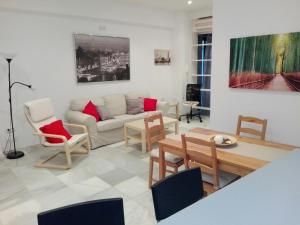 salon z kanapą i stołem w obiekcie Céntrico Apartamento con Patio Privado w Sewilli
