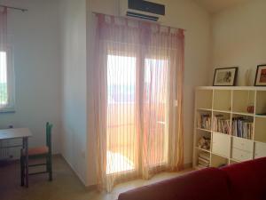 una sala de estar con una ventana con cortinas y una mesa en Apartments Explore Istria 4, en Pula