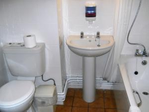 uma casa de banho branca com um WC e um lavatório em The Oakland Hotel em Woodham Ferrers