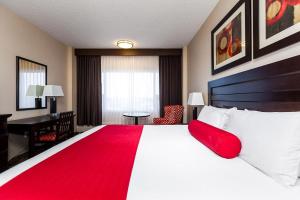 a hotel room with a large bed with a red blanket at Century Casino & Hotel Edmonton in Edmonton