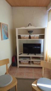 a white entertainment center with a television in a living room at Premantura Studio apartman in Premantura