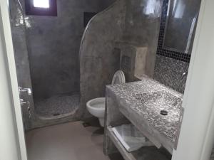 a bathroom with a sink and a toilet and a shower at Mihal Suites in Sarandë