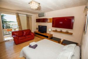 um quarto com uma cama, um sofá e uma televisão em Sebenicum Apartments em Sibenik