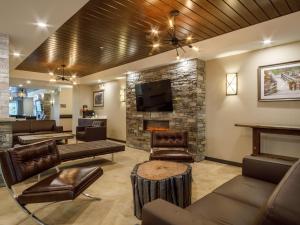 sala de estar con chimenea y TV en Ramada by Wyndham Revelstoke en Revelstoke