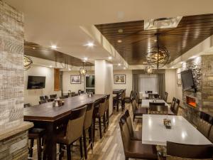 Ramada by Wyndham Revelstoke في ريفيلستوك: غرفة طعام كبيرة مع طاولات وكراسي