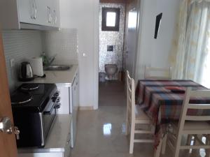 a kitchen with a table and a stove and a kitchen with a table and chairs at Mihal Suites in Sarandë