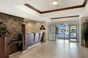 an office lobby with a reception counter and a brick wall at Ramada by Wyndham Wainwright in Wainwright