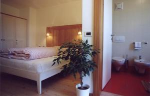 a bedroom with a bed and a potted plant at Al Cargà in San Vigilio Di Marebbe