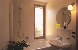 a bathroom with a tub and a sink and a window at Al Cargà in San Vigilio Di Marebbe