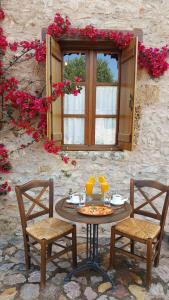 a table with two chairs and a pizza on it at Liotrivi Historical Mansion and Boutique Hotel in Monemvasia