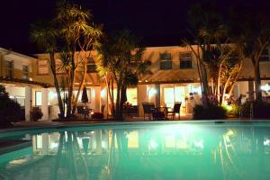 a swimming pool in front of a house at night at La Place Country Cottages in Saint Aubin