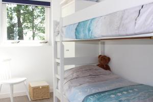 Sint MaartensvlotbrugにあるVakantiehuis aan zeeの二段ベッド1組(テディベア付)が備わるベッドルームです。
