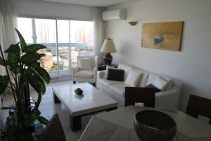 een woonkamer met een bank en een tafel bij Torre Long Beach in Punta del Este
