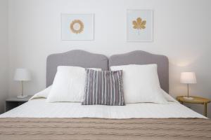 a white bed with two pillows and two lamps at Angelina Apartments Amalfi Coast in Maiori