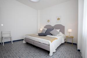 a white bedroom with a bed and two tables at Angelina Apartments Amalfi Coast in Maiori +142 photos