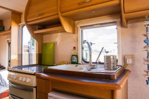 蒂納霍的住宿－Caravan Apartment，厨房设有水槽和窗户。