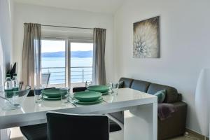 a dining room with a table with green dishes on it at Apartments & Rooms Kata - Adults Only in Senj