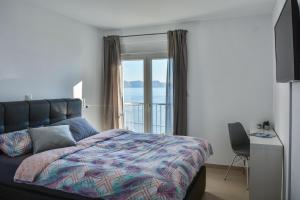 a bedroom with a bed with a view of the ocean at Apartments & Rooms Kata - Adults Only in Senj