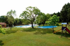 a park with a pool and a swing set in the grass at Casa Hipolito in Corduente
