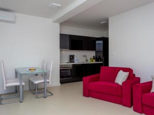 een woonkamer met 2 rode stoelen en een tafel bij Residences Bellavista 1 in Novalja