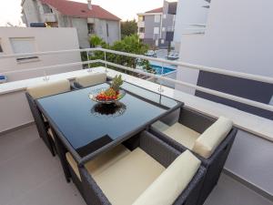 een tafel en stoelen op het balkon van een appartement bij Residences Bellavista 1 in Novalja