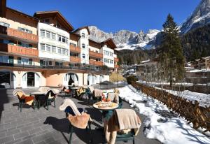 a patio with tables and chairs in front of a building at Residence Pez Gajard in San Martino di Castrozza