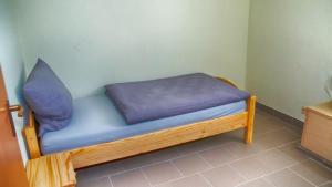 a wooden bench with a blue pillow on it at Ferien- und Monteurwohnung in Wohnbach in Wölfersheim