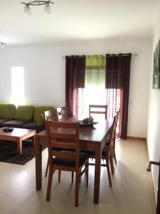 a dining room with a table and chairs and a couch at Nazaré T2 Vista Mar in Nazaré