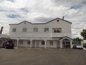 un hombre de pie en la parte superior de un edificio blanco en Colorado Inn Motel, en Canon City