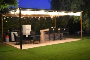 a gazebo with a table and chairs under it at Los Olivos Villa in Sanlúcar de Barrameda