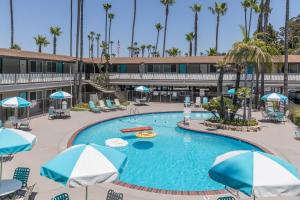a large pool with chairs and umbrellas in a hotel at Kings Inn in San Diego