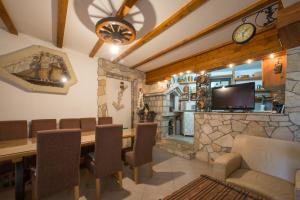 a dining room with a table and chairs and a tv at Apartmani Krgušić in Tivat