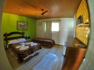 a hotel room with two beds and green walls at Pousada da Praia in Mangaratiba