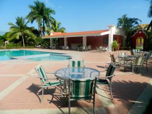 a patio with tables and chairs next to a pool at Hotel Santa Maria de Comayagua in Comayagua
