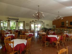 ein Esszimmer mit Tischen, Stühlen und einem Kronleuchter in der Unterkunft Hotel Santa Maria de Comayagua in Comayagua