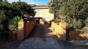 a brick fence in front of a house at Gillroyhouse in Port Alfred
