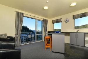 a kitchen with a view of a living room at Tombstone Motel, Lodge & Backpackers in Picton
