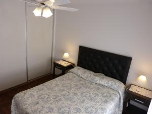 1 dormitorio con 1 cama y 2 mesas con lámparas en Departamentos Córdoba Vaes en Córdoba