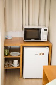 a kitchen with a microwave, refrigerator, and dishwasher at Morada Bem Me Quer in Canela