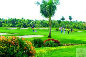 a group of people playing golf on a golf course at Queens Island Golf and Resort in Medellin