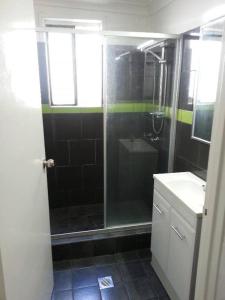 uma casa de banho com um chuveiro e um lavatório. em Gonow Family Backpackers Hostel em Brisbane