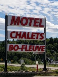 a sign on a pole on a street at Motel et Chalets Bo-Fleuve Evangeline in Saint-Siméon