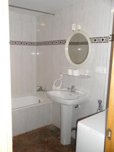 a bathroom with a sink and a mirror and a tub at Edificio Mirasierra in Oropesa del Mar