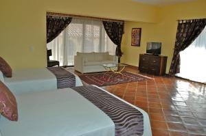 una habitación de hotel con dos camas y un sofá en Hotel Regalo del Alma, en Tequisquiapan