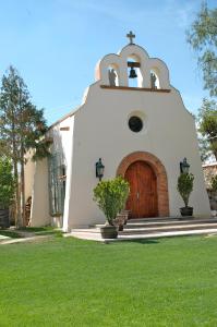una iglesia con una puerta de madera y un campo de césped en Hotel Regalo del Alma, en Tequisquiapan