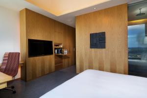a hotel room with a bed and a flat screen tv at Oasia Hotel Novena, Singapore by Far East Hospitality in Singapore