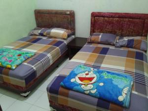 two beds sitting next to each other in a room at Titan's Greenhouse in Banyuwangi