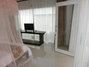 Lombok Holiday Hotel في كوتا لومبوك: غرفة نوم بسرير ومرآة ومكتب