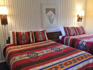 um quarto de hotel com duas camas com cobertores coloridos em Sharon Motel em Wells